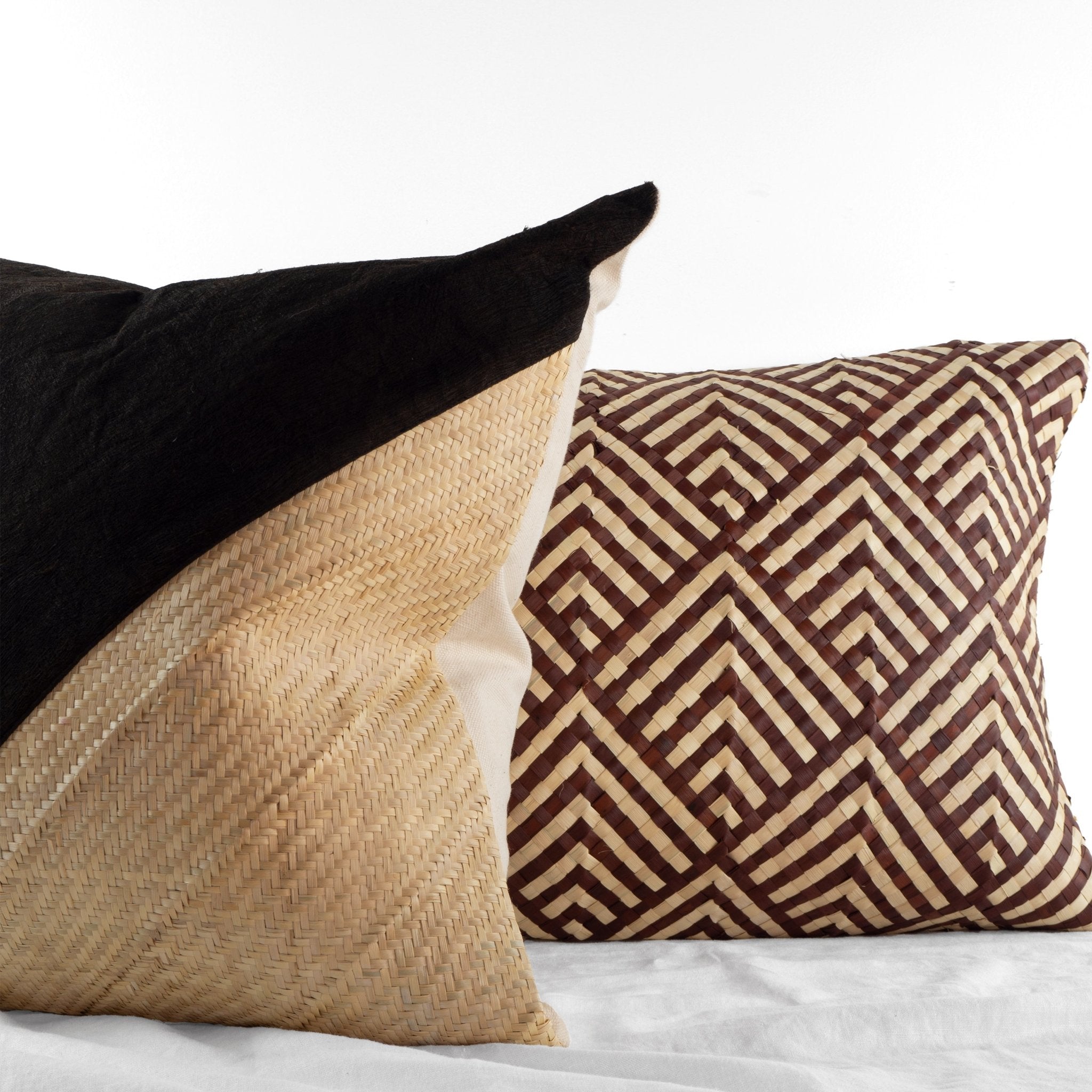 Two handwoven barkcloth and palm leaf cushions in intricate patterns from Kampala, Uganda