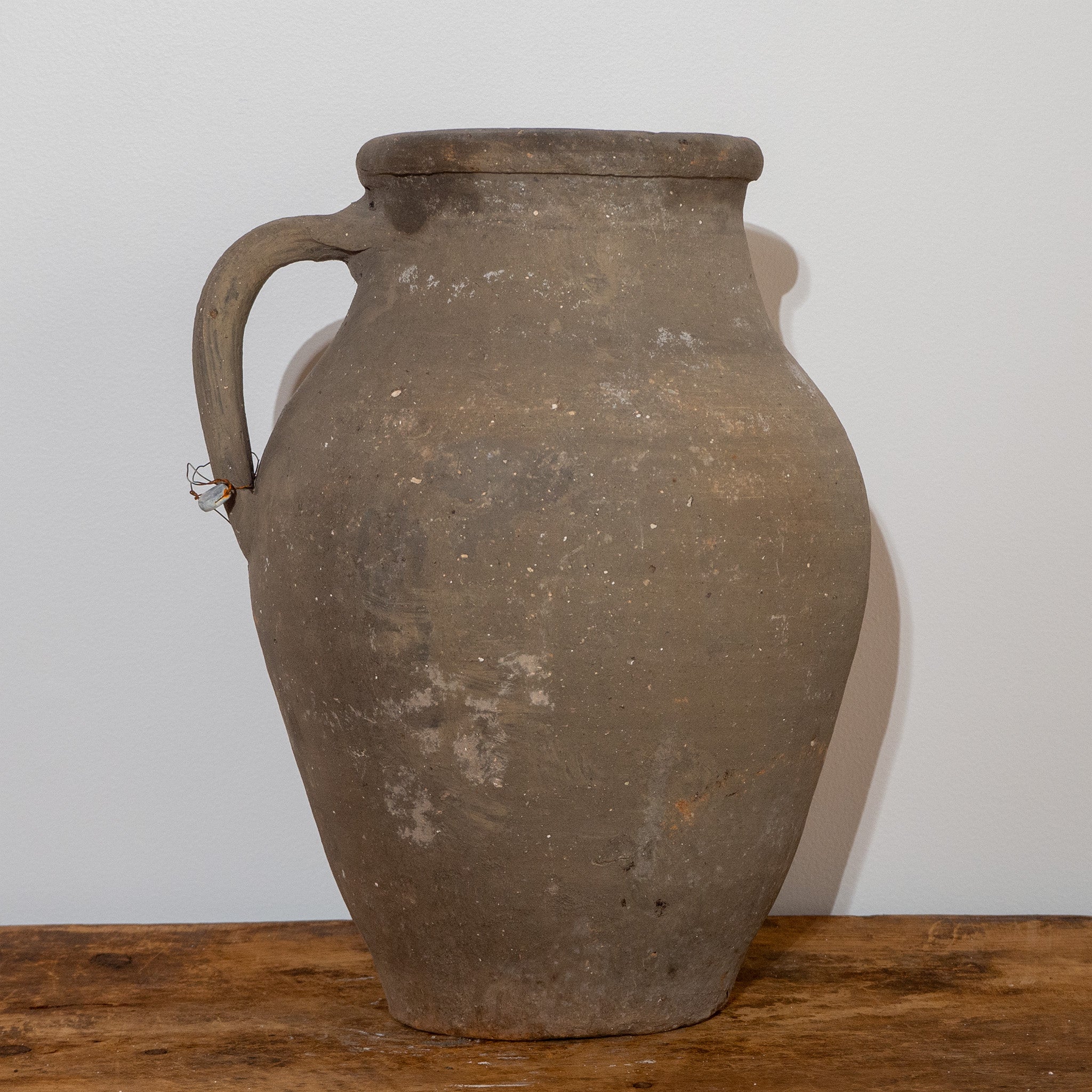 Vintage Turkish black single handled jug urn on vintage wooden bench