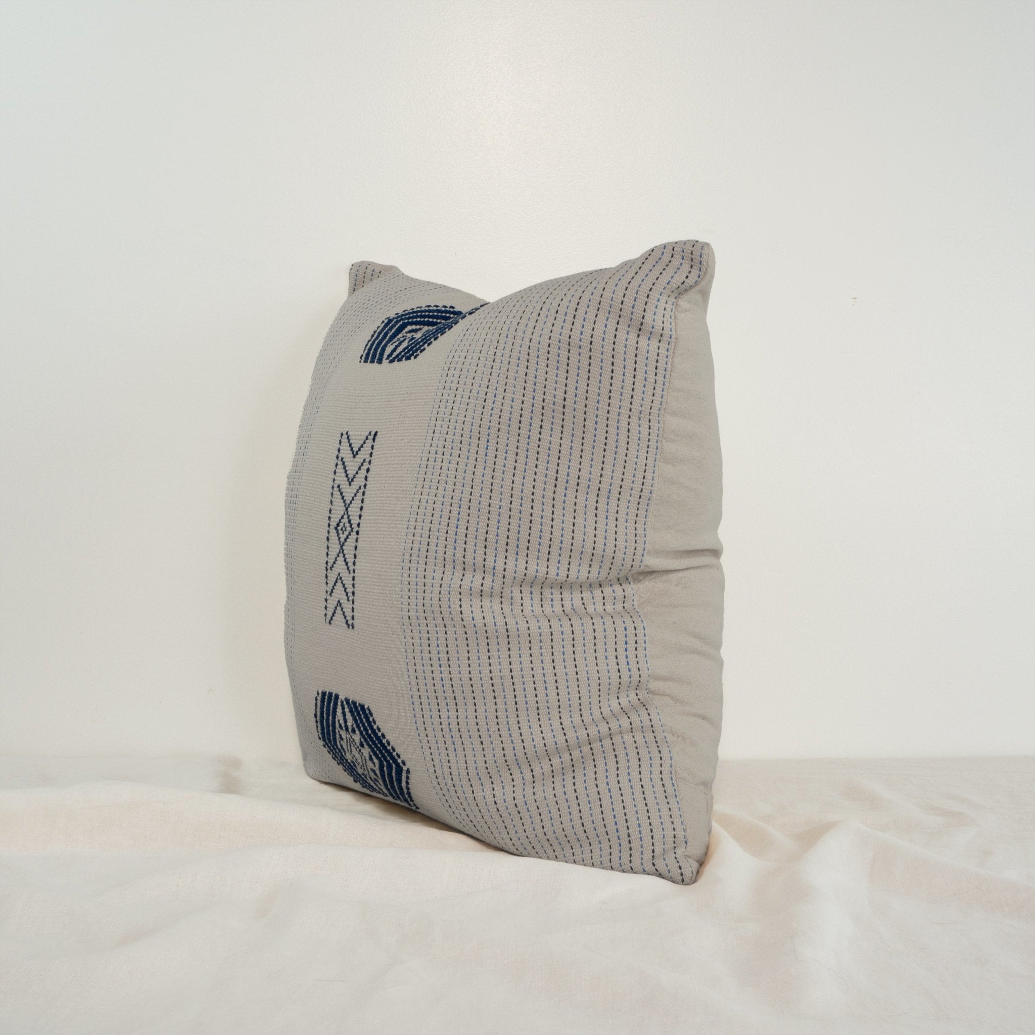 Handwoven cotton square throw cushion in white with navy traditional Nagaland motif from India