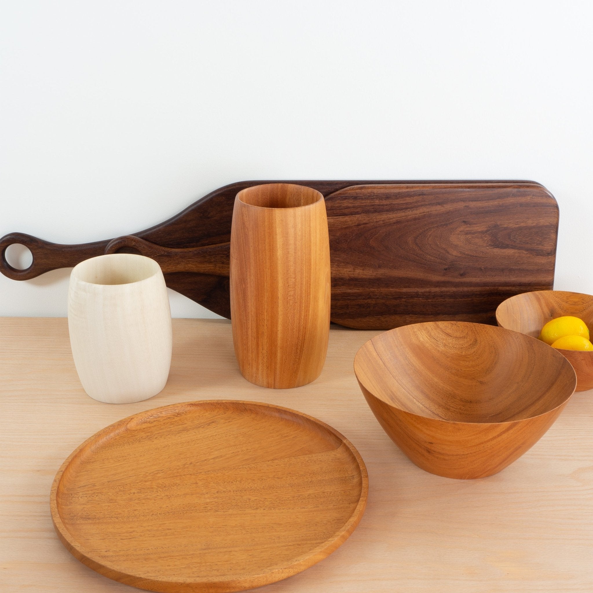 Collection of handwoven vases, paddle charcuterie boards, bowls and round serving platters in melina wood, mahogany and granadillo